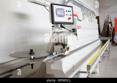 Kharkiv, Ukraine - July 12, 2016: Side view on single sided automatic edge banders in a private furniture workshop, selective focus Stock Photo