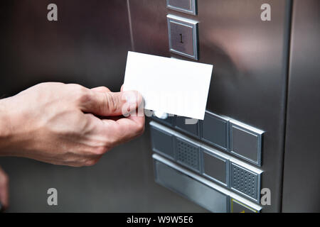 Close-up Of A Person Holding Key Card Near Elevator Button Stock Photo