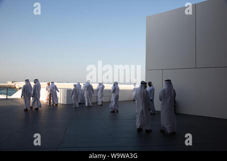 Emiratis in traditional dress at the Louvre Abu Dhabi. --- The Louvre Abu Dhabi is an art and civilization museum, located in Abu Dhabi, UAE Stock Photo