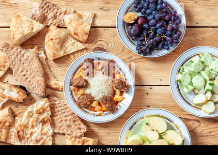 Table full with different foods. Yummy dinner table with fresh vegetables, fruits, bread and sweets. Different types of food Stock Photo