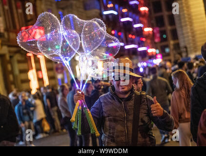 15 August 2019, Hessen, Frankfurt/Main: A man sells heart-shaped balloons on station quarter night. Every year the Frankfurters celebrate the railway station district with the street festival. (to dpa 'Frankfurt celebrates station quarter with big street festival') Photo: Boris Roessler/dpa Stock Photo