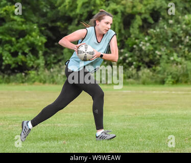 Female player running with the rugby ball in hand at amateur Touch Rugby festival at Lowestoft in July 2019 Stock Photo