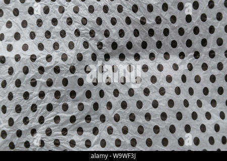 Wrinkled crumpled black polka dot on white wrapping paper texture and background. Stock Photo