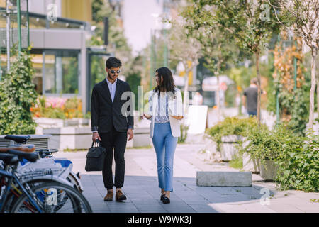 Happy Caucasian business man and woman walking and talking after finish work Stock Photo