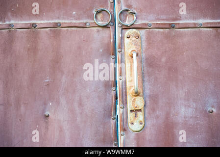 Close up old red door and rusty door handle Stock Photo