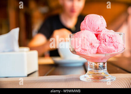 Close up three balls of strawberry ice cream in glass bowl Stock Photo