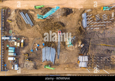 Aerial drone view of excavator loading the tipper truck at the construction site Stock Photo