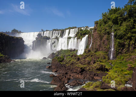 Beautiful view of waterfalls on Iguazu river in sunny summer day. Foz de iguaçu divides the border between Brazil and Argentina and is One of the Seve Stock Photo