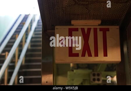 New London, CT / USA: June 22, 2019: Exit sign pointing to the stairs leading up