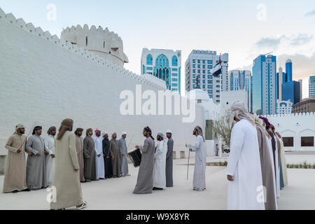 Emirati (Middle Eastern) Men performing a traditional dance in the heritage of the United Arab Emirates - The Yowla Stock Photo