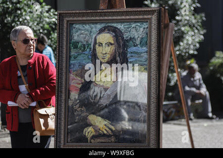 Sao Paulo, Brazil. 15th Aug, 2019. A pedestrian passes by a remake of 'Mona Lisa' at 'Unwanted Museum' street exhibition in Sao Paulo, Brazil, Aug. 15, 2019. Six remakes of world-famous art works made with plastic bags collected from the city's riversides and recycling cooperatives were displayed during the exhibition, organized to raise awareness of the impact of plastics on nature. Credit: Rahel Patrasso/Xinhua/Alamy Live News Stock Photo