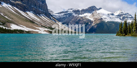 Bow Lake - A panoramic Spring view of colorful Bow Lake at base of Mount Jimmy Simpson and Crowfoot Mountain, Banff National Park, Alberta, Canada. Stock Photo