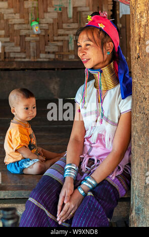 Portrait of a long neck woman or Paduang of the Karen ethnic tribe, with her child, in the region of Mae Hong Son by the border with Myanmar, Thailand.