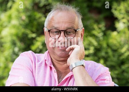 Freital, Germany. 14th Aug, 2019. The German actor Hilmar Eichhorn sits in his garden. Eichhorn celebrates his 65th birthday on 18 August. Credit: Sebastian Kahnert/dpa-Zentralbild/dpa/Alamy Live News Stock Photo