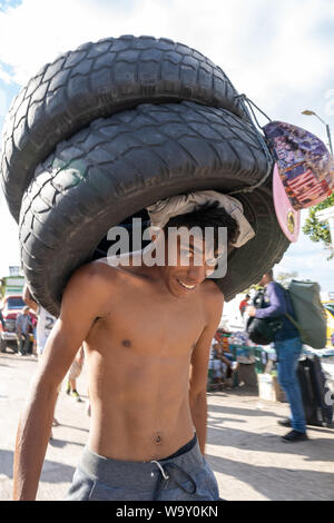 Cucuta, Norde De Santander, Colombia. 9th Aug, 2019. A man seen carrying tyres at the Venezuela Colombia border crossing in Cucuta.Thousands of Venezuelans cross the Simon Bolivar Bridge into Cucuta, Colombia. Some leave to gather supplies returning to Venezuela. Others leave permanently, hoping for a life with dignity. Credit: Enzo Tomasiello/SOPA Images/ZUMA Wire/Alamy Live News Stock Photo