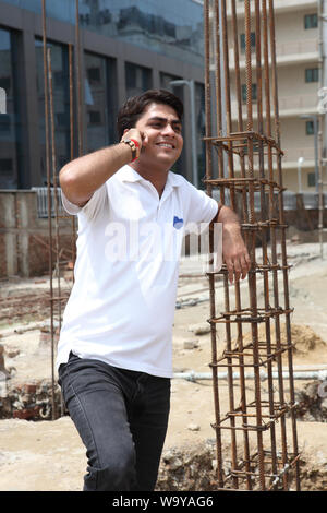 Surveyor talking on a mobile phone at construction site Stock Photo