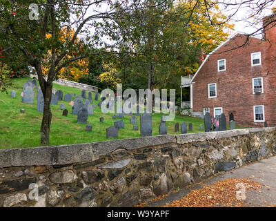 Concord, Mass / USA - Oct 14, 2018: Tombstones from Concord’s earliest burial site; the earliest (marked) date of death is 1677. House built in 1701. Stock Photo