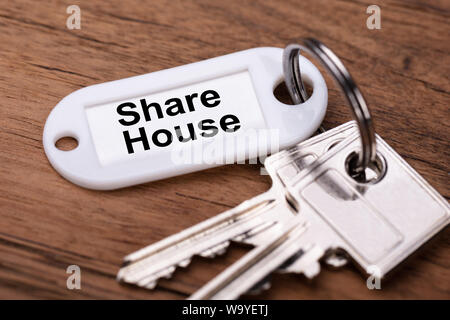 Close-up Of Share House Keys On Wooden Desk Stock Photo