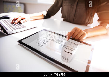 Close-up Of A Busineswoman's Hand Working With Invoice On Digital Tablet Stock Photo