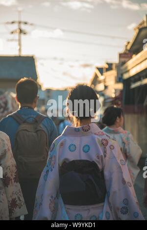 Vertical closeup shot of a female with her hair tied in a traditional bun wearing Japanese kimono Stock Photo