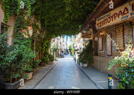 Athens, Greece - August 4, 2019: Plaka, Charming shady narrow street with lush greenery in historic center Stock Photo