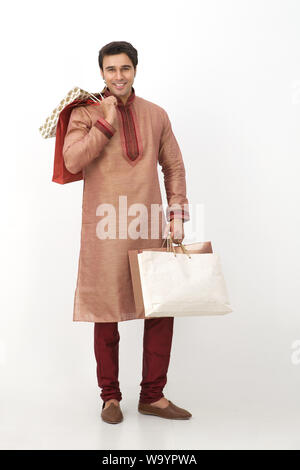 Young man carrying shopping bags and smiling Stock Photo