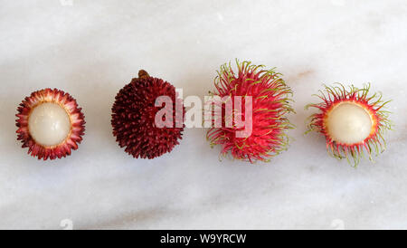 Top view of pulasan and rambutan fruit, arranged side by side. Both are tropical fruits from southeast Asia, and sometimes confused for one another. Stock Photo