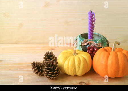 Home Decorations with Vibrant Color Ripe Pumpkins, Natural Pine Cones and Purple Candle in Grape Motif Holder Stock Photo