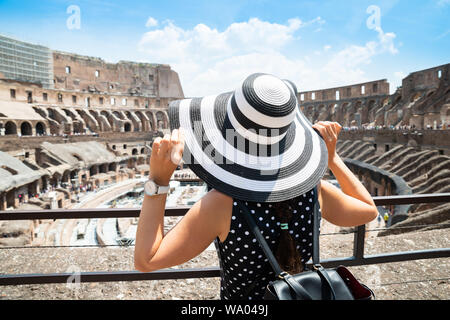 Rear View Of Female Tourist Standing Inside Colosseum In Rome Looking At Arena Stock Photo