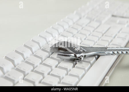 Wrench on a computer keyboard Stock Photo