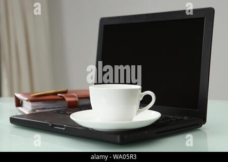 Tea cup on a laptop Stock Photo