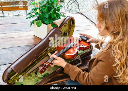 Womans hands holds old violin in case closeup Stock Photo