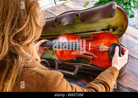 Womans hands holds old violin in case closeup Stock Photo