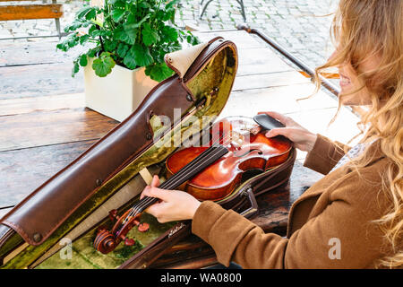 Womans hands holds old violin in case closeup Stock Photo