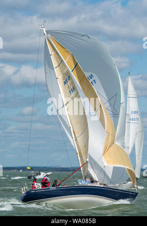 A large racing yacht under full sail and spinnaker on the sea in rough weather at cowes eek annual regatta on the Isle of Wight. Stock Photo