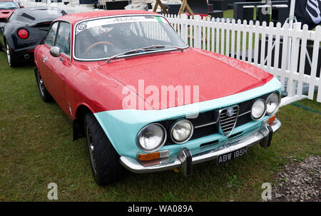 Three-quarter front view of a Red, 1975, Alfa Romeo 1750 GTV on display in the Alfa Romeo Owners Club Zone, at the 2019 Silverstone Classic