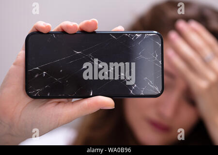 Woman Hand Holding Smartphone With Cracked Screen Stock Photo