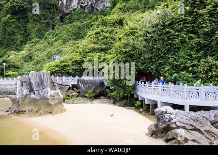 Walkway with happy tourists returning from visiting Hang Dau Go cave on Dau Go Island. Halong Bay in South China Sea. Vietnam, Asia