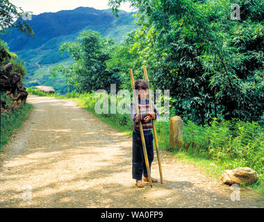 Lonely young boy standing on the road, a village outside Sapa, Vietnam. Stock Photo
