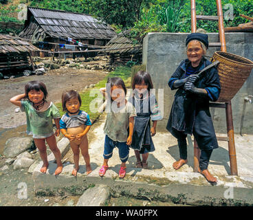 Old grandmother and happy kids poses in the yard, a village outside Sapa, Vietnam. Stock Photo