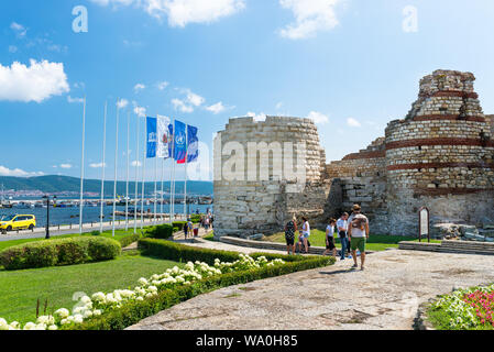 Nessebar, Bulgaria July 15, 2019. A crowd of people walking around the ancient city of Nessebar in Bulgaria.Ruins of fortifications at the entrance. Stock Photo