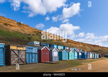 Beach huts at Barton-on-Sea on a warm sunny day at Barton on Sea, Hampshire, UK in August Stock Photo