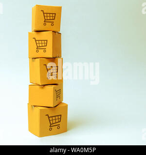 Tower of cardboard boxes with pattern of shopping carts on a blue background. commerce, online shopping. E-commerce, logistics, distribution and sales Stock Photo