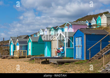 Beach huts at Hordle Cliffs West, Milford-on-Sea on a warm sunny day at Milford on Sea, Hampshire, UK in August Stock Photo