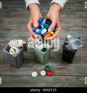 Ecology concept, a lot of recyclable objects in containers on the wooden background. Stock Photo
