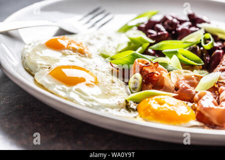 English Breakfast with eggs, bacon, beans and iyoung onion in white plate Stock Photo