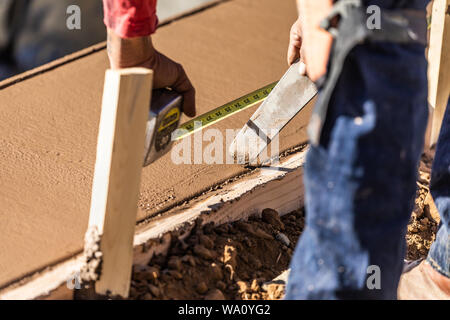 Cement Construction Worker Using Measuring Tape While Forming Pool Coping. Stock Photo