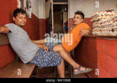 Nepalese men relaxing in a shop selling eggs Stock Photo