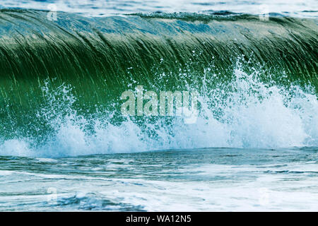 A large wave, formed by a storm offshore, crashes on the shoreline of Fire Island New York. Stock Photo