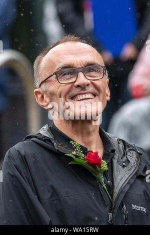 Manchester, UK. 16 August 2019. Protestors and demonstrators commemorate the 200th anniversary of the Peterloo massacre in Manchester. Film director Danny Boyle joined performers marking the event whilst a crowd of thousands braved torrential rain and wind. Credit: Benjamin Wareing/ Alamy Live News Stock Photo